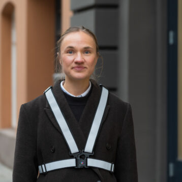 Kvinne som ser i kamera med svart reflekssele på