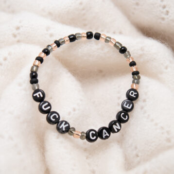 Armbånd med svarte perler på hvit bakgrunn.